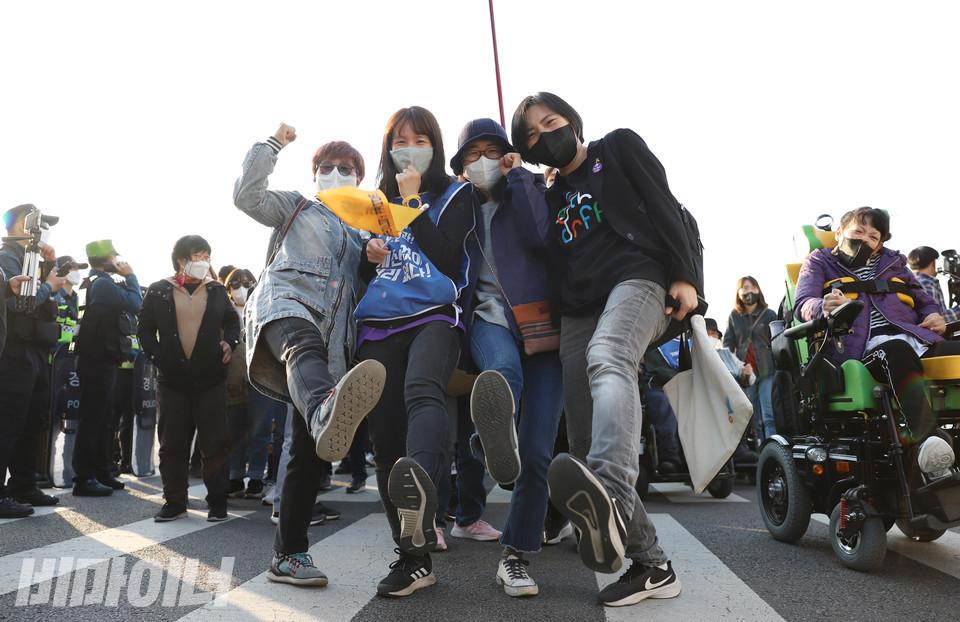 지난 4월 20일 ‘장애인차별철폐의 날’ 행진 도중 장애와인권발바닥행동 활동가들이 발바닥행동을 의미하는 한 발을 크게 내딛는 포즈를 취하고 있다. 왼쪽에서부터 박옥순, 이정하, 미소, 김정하 활동가. 사진 강혜민  