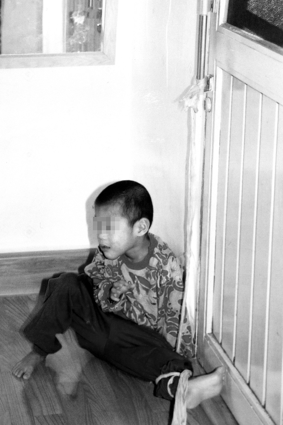 S재단 인권침해를 알리는 제보 사진. 어린 소년의 발목이 문고리에 끈으로 묶여 있다. 사진 제공 장애와인권발바닥행동