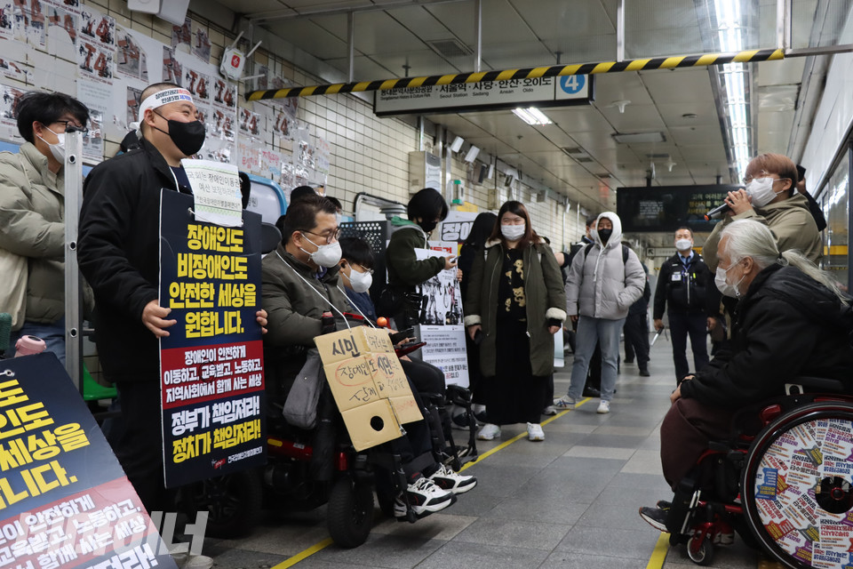 지난 15일 서울 삼각지역에서 지하철 선전전을 끝내고 혜화역 승강장에 모인 전국장애인차별철폐연대 활동가들이 장애인권리예산을 의결하는 국민의힘 의원들의 책임을 촉구하고 있다. 사진 복건우