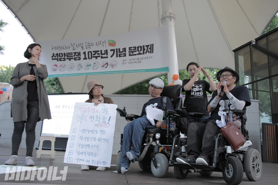 2019년 6월 4일, 마로니에공원에서 석암투쟁 10주년을 맞이한 기념 문화제가 열렸다. 임소연 활동가가 석암투쟁의 주역인 한규선, 김진수 활동가와 석암투쟁이 만든 변화에 대해 이야기를 나누고 있다. 사진 강혜민 