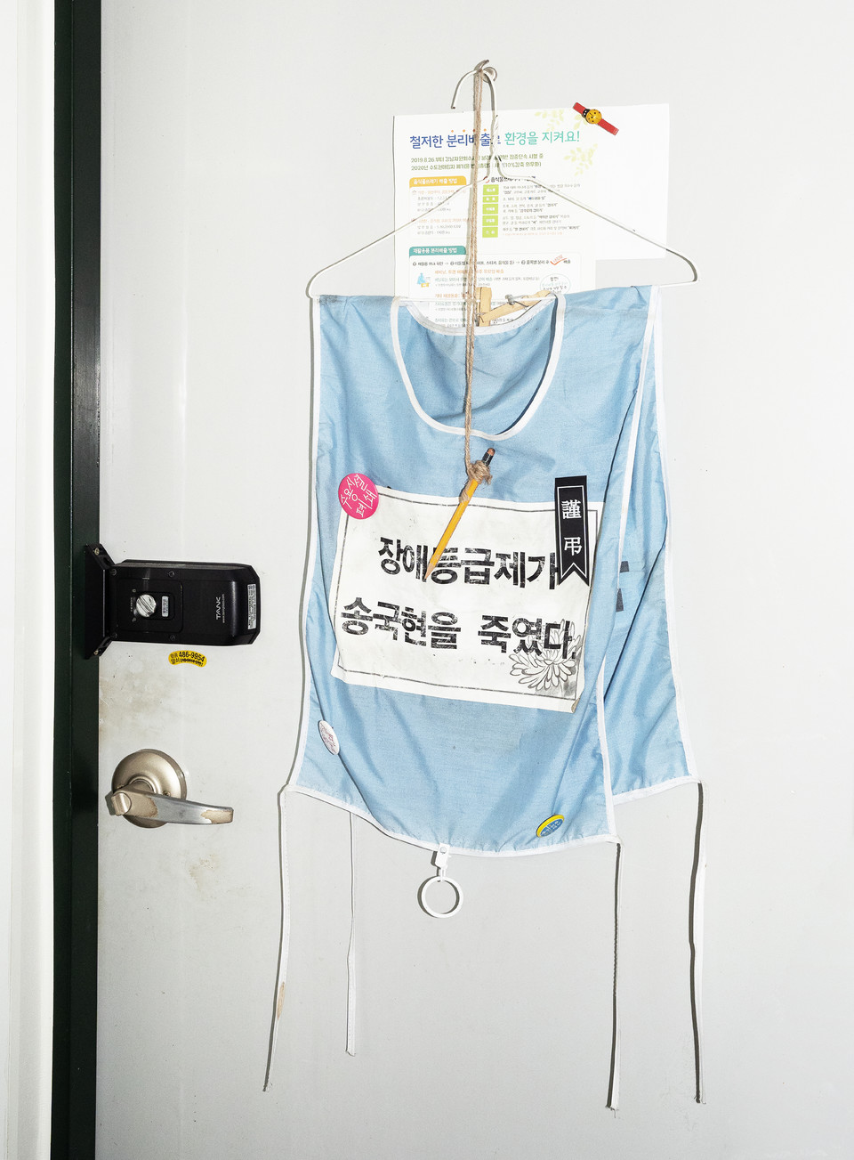 임소연 활동가의 집 현관문에는 송국현 장례투쟁 당시 입었던 몸피씨가 걸려 있다. 근조 리본과 함께 “장애등급제가 송국현을 죽였다”는 문구가 있다. 사진 현다혜