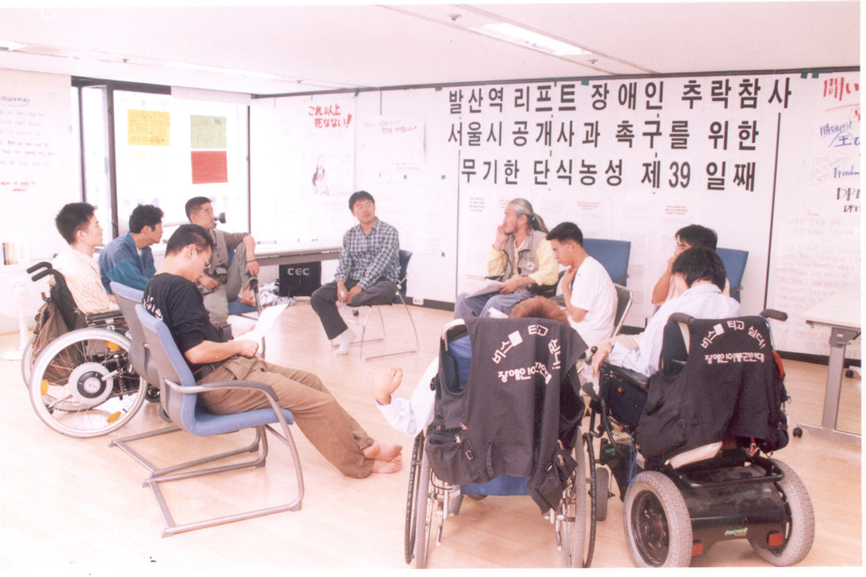 2002년 9월 29일, 장애인이동권연대는 국가인권위원회를 점거하고 서울시에 발산역 리프트 장애인 추락 참사에 대한 공개 사과를 촉구하며 무기한 단식을 했다. 서울시가 이동권 보장 대책을 발표하면서 박경석 대표는 단식 39일 만에 중단했다. 왼쪽에서 네 번째 뒷줄에 앉아 한쪽 다리를 의자 위에 올리고 있는 사람이 김도현 활동가. 사진 제공 김도현