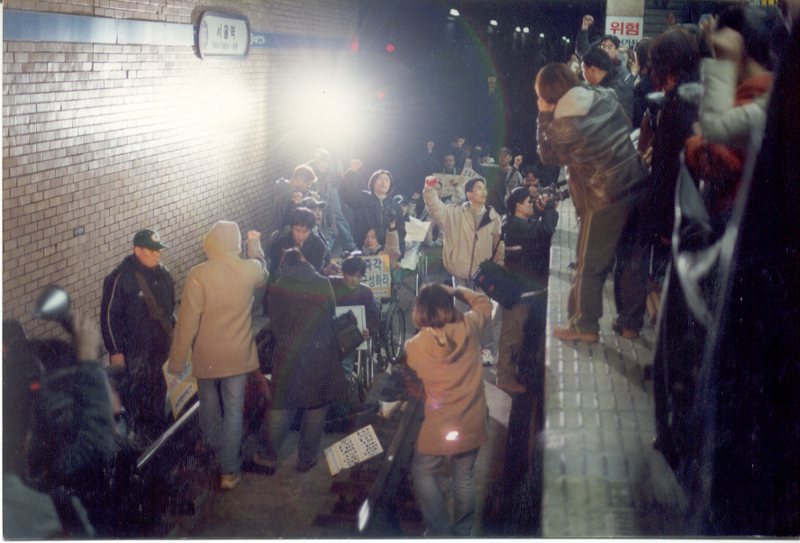 2001년 2월, 서울역 지하철 선로를 점거한 사람들. 김도현 활동가는 오른쪽 위 승강장에서 구호를 외치고 있다. ‘위험’이라는 글자 아래 그의 얼굴 반쪽이 보인다. 사진 제공 김도현