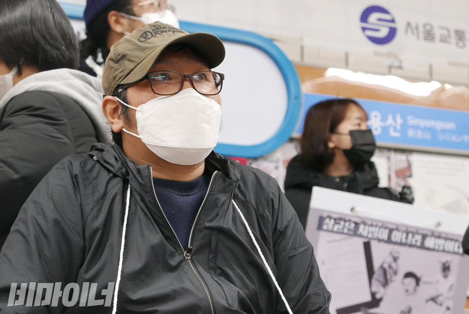 삭발 전 한정우 노들장애인야학 학생의 모습. 갈색 모자에 뿔테 안경, 하얀 마스크를 썼다. 까만색 점퍼와 남색 티를 입고 있다. 사진 양유진