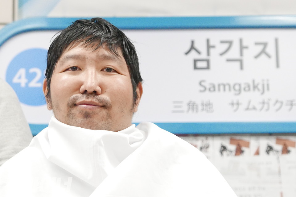 삭발하기 위해 가운을 두른 한정우 노들장애인야학 학생. 사진 양유진