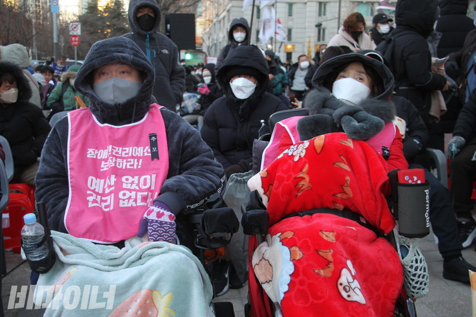 영하 10도의 추운 날씨에 담요를 온몸에 두른 장애인 활동가들이 결의대회에 참석하고 있다. 사진 강혜민 