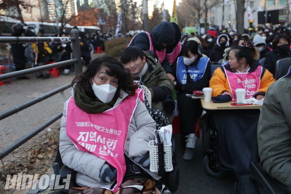 30번째 세계장애인의 날을 앞둔 1일, 전국장애인차별철폐연대가 여의도에 있는 T4철폐 농성장에서 결의대회를 열었다. 대구에서 온 장애인 활동가들이 한파 속에서도 자리를 지키고 있다. ‘이동하고 교육받고 노동하고 지역사회 함께 살자!’고 적힌 분홍 몸피씨를 입고 있다. 사진 강혜민 