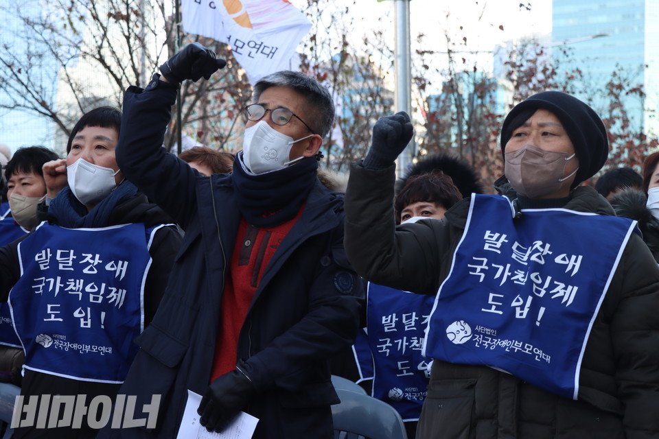 전국장애인부모연대 활동가들이 주먹을 쥐고 “투쟁”을 외치고 있다. 사진 강혜민
