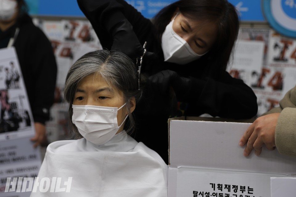 10월 18일, 124차 삭발결의식 현장. 풍경 전북장애인차별철폐연대 집행위원장(왼쪽)이 삭발 투쟁을 하고 있다. 강희석 나야장애인인권교육센터 활동가(오른쪽)가 가위로 풍경 집행위원장의 머리카락을 자르고 있다. 사진 복건우