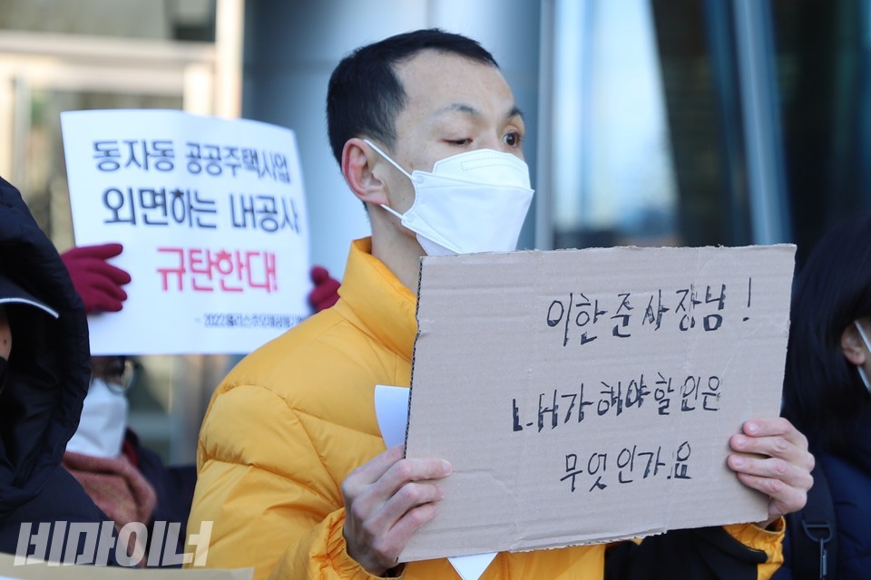 정대철 사랑방마을주민협동회 사업이사가 ‘이한준 사장님! LH가 해야 할 일은 무엇인가요’라고 적은 피켓을 들고 있다. 그 뒤 최현숙 작가가 ‘동자동 공공주택사업 외면하는 LH공사 규탄한다’라고 적힌 피켓을 높이 들고 있다. 사진 하민지