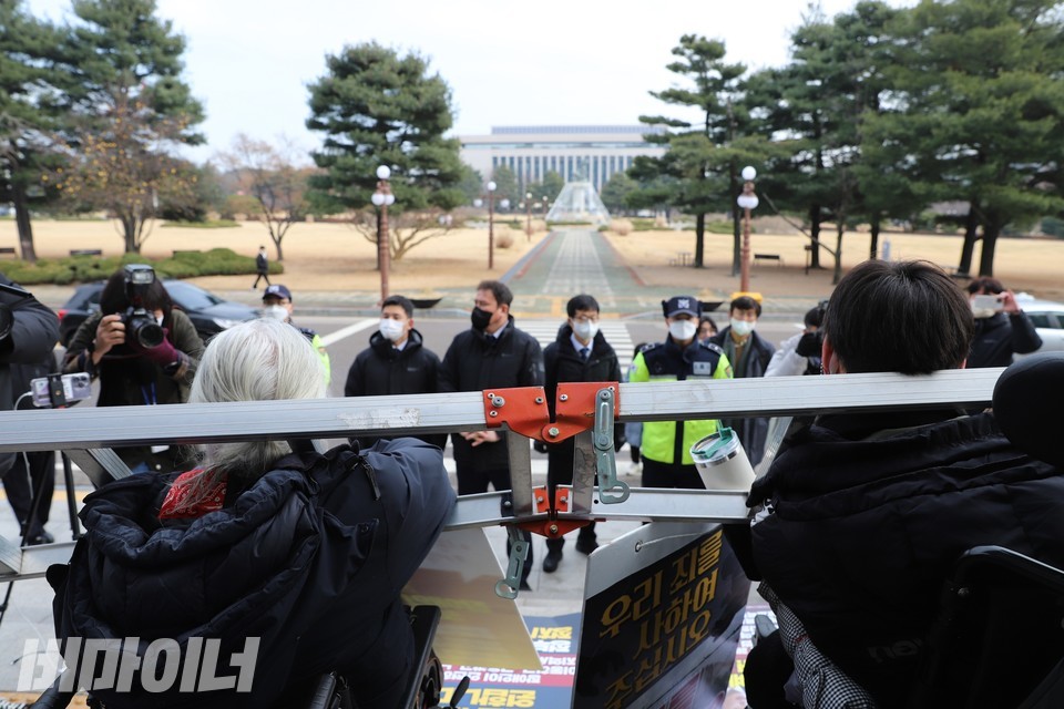 박경석 전장연 상임공동대표(왼쪽)와 유진우 노들장애인자립생활센터 활동가(오른쪽)이 사다리를 목에 걸고 있다. 사진 하민지