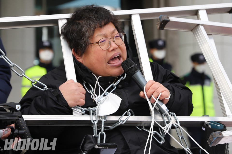 이형숙 서울시장애인자립생활센터협의회 회장이 마이크를 잡고 발언하고 있다. 뒤로 경찰들이 보인다. 사진 하민지