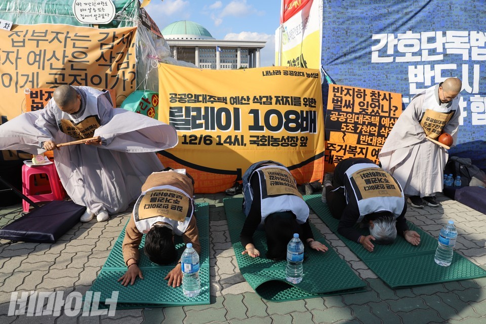 조계종 사회노동위원회 동신스님(제일 왼쪽)이 죽비를 치고 현성스님(제일 오른쪽)이 목탁을 두드리며 108배가 진행되고 있다. 절 하는 사람은 왼쪽부터 이원호 빈곤사회연대 집행위원장, 김혜미 용산정비창개발의공공성강화를위한공대위 위원장, 조희주 용산참사진상규명위원회 공동대표다. 사진 하민지