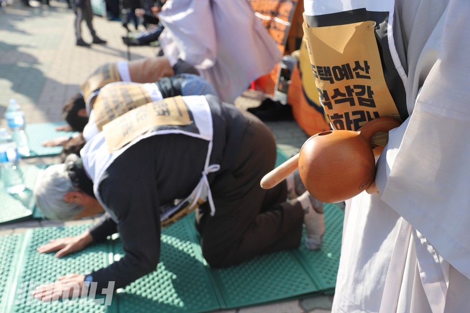 현성스님이 목탁을 두드리고, 108배 투쟁 참가자들이 절하고 있다. 사진 하민지