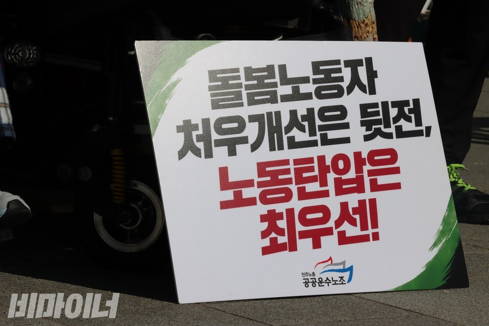 한 장애인 활동가가 자신의 휠체어 바퀴 앞에 ‘돌봄노동자 처우개선은 뒷전, 노동탄압은 최우선!’이라 적힌 피켓을 내려놨다. 사진 하민지