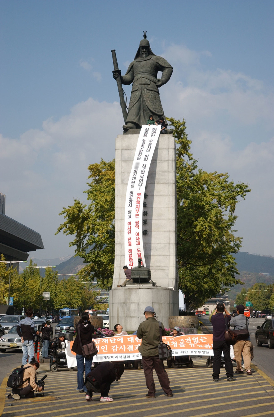 종로구청 앞 농성 100일이 되던 2006년 11월 2일, 송효정 활동가는 광화문 이순신 동상 위에 올랐다. S재단 비리 척결을 촉구하는 대형 현수막을 내리고 있다. 사진 n_m 