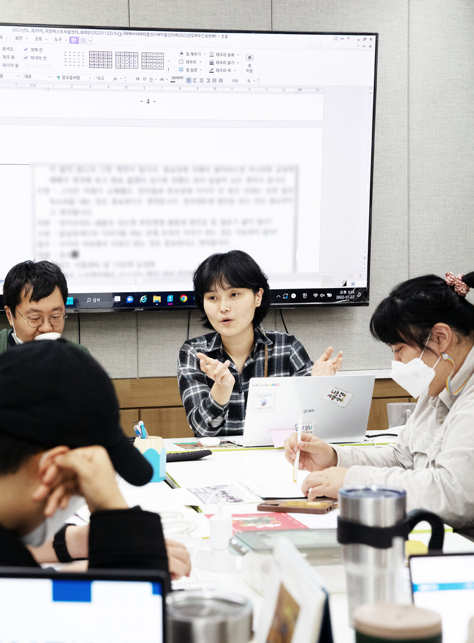 지난 11월 22일, 피플퍼스트서울센터 활동가들이 다함께 회의를 하고 있다. 송효정 활동가 왼쪽에는 박현철 센터장이, 오른쪽에는 박경인 활동가가 앉아 있다. 송효정 활동가 뒤로는 커다란 화면에 회의가 속기되고 있다. 사진 현다혜