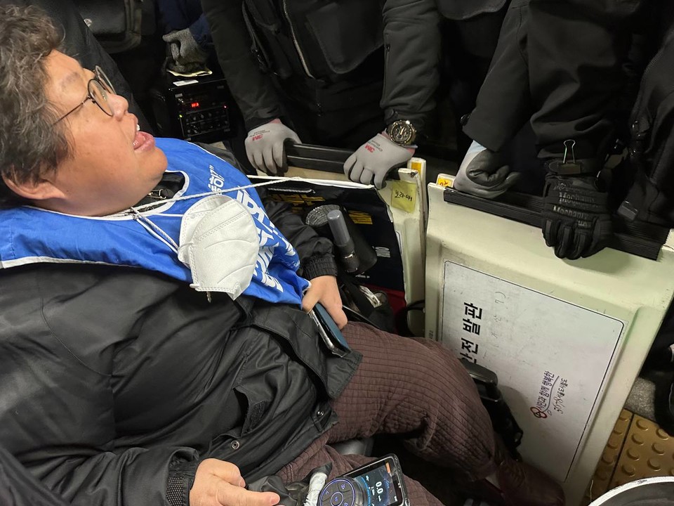 이형숙 서울시장애인자립생활센터협의회 회장이 지하철에 탑승하려고 하자 서울교통공사 측이 휠체어 이용자 탑승을 위해 준비한 발판으로 막아서고 있다. 사진 전장연