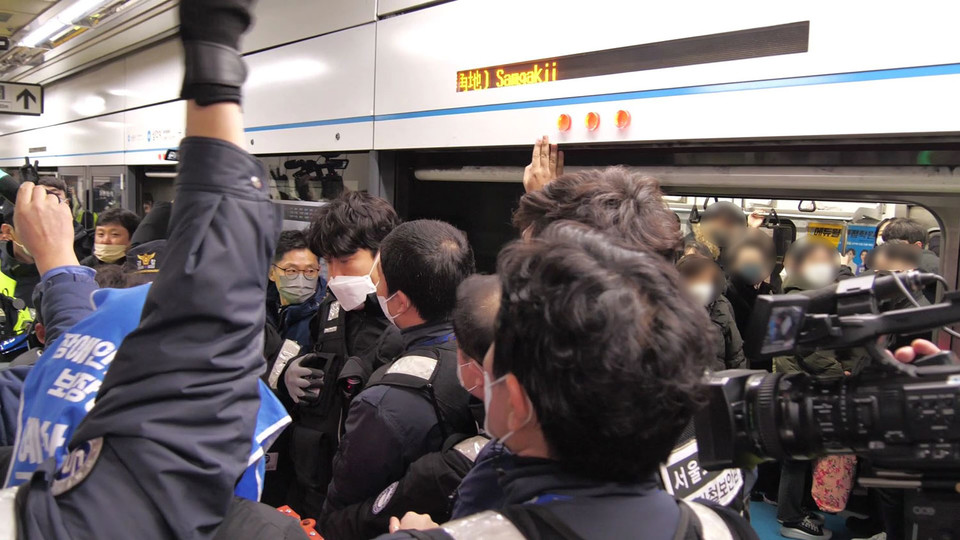 서울교통공사 직원들이 지하철을 탑승하려는 전장연 활동가들을 막아서고 있다. 사진 아영 