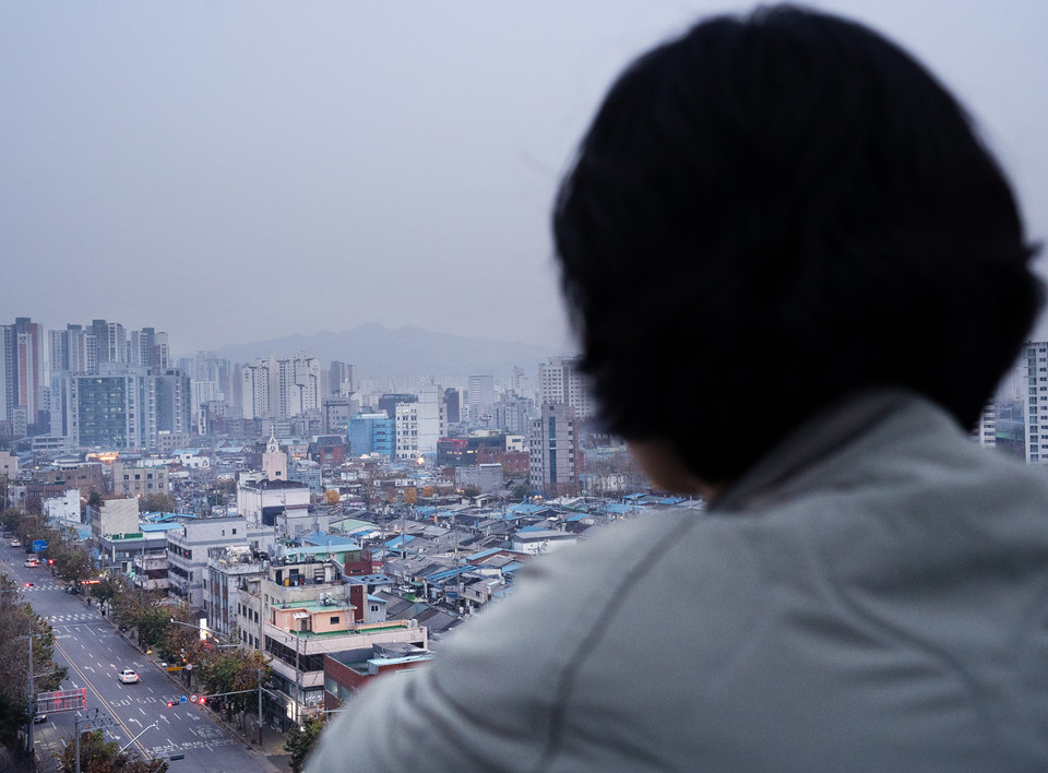 송효정 활동가의 뒷모습. 피플센터가 있는 건물 옥상에서 서울 도심을 내려다보고 있다. 사진 현다혜
