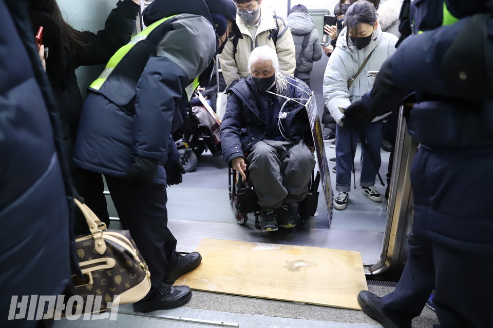 코레일 직원이 가져온 낡은 널빤지. 그 위를 박경석 전장연 상임공동대표가 지나가려 하고 있다. 사진 하민지