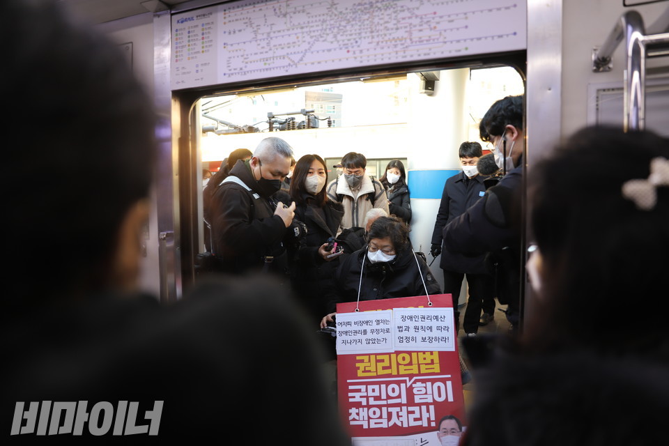 이형숙 회장이 열차에 승차하고 있다. 이를 바라보는 승객들이 이 회장을 비난하고 있다. 사진 하민지
