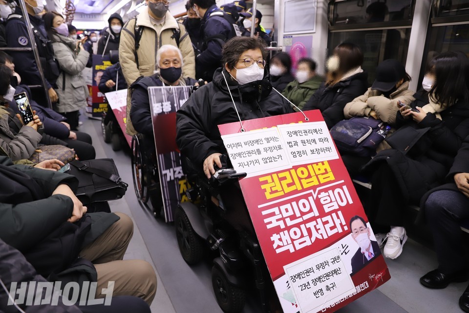 이형숙 서울시장애인자립생활센터협의회 회장이 열차에 탑승해 있다. 이 회장은 “어차피 비장애인 열차는 장애인권리를 무정차로 지나가지 않았는가”, “장애인권리예산, 법과 원칙에 따라 엄정히 보장하라” 등이 적힌 피켓을 목에 걸고 있다. 사진 하민지