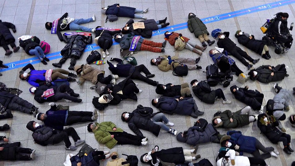 서울역의 홈리스 퇴거를 규탄하며 바닥에 누운 기획단. 사진 은석