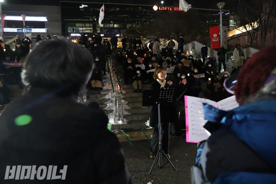 날라 지휘자가 환하게 웃으며 지휘하고 있다. 사진 하민지