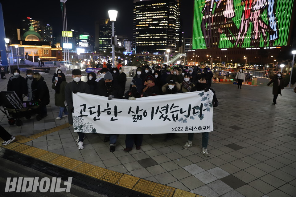 2022홈리스추모제공동기획단이 서울역 대합실 안으로 들어가고 있다. 현수막에 “고단한 삶이셨습니다”라고 적혀 있다. 사진 하민지