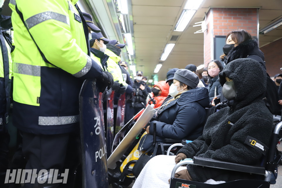 전장연 활동가들이 열차에 타지 못하도록 막아선 경찰. 사진 하민지