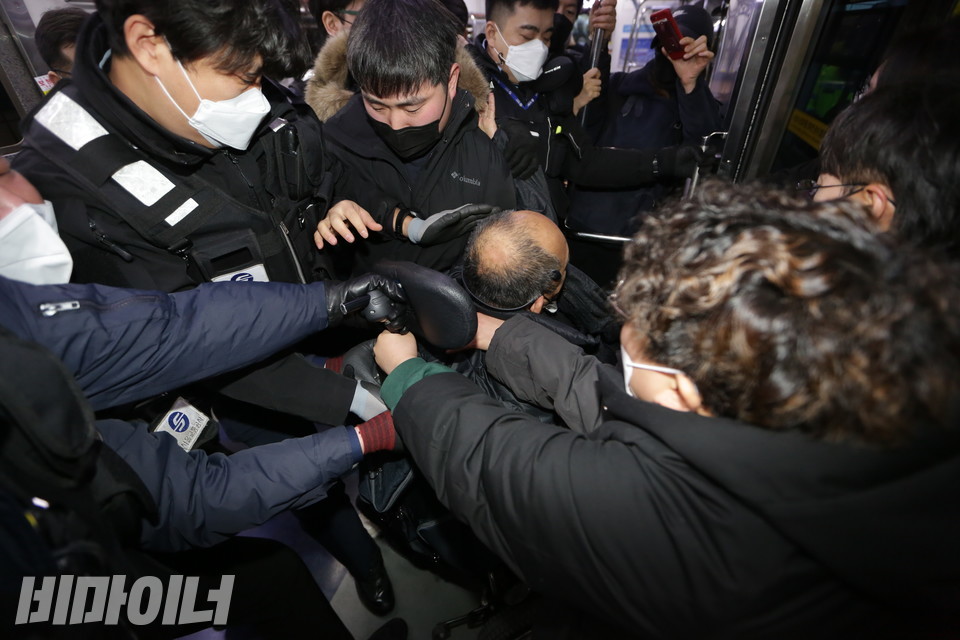 이규식 서울장애인차별철폐연대 대표가 동대문역사문화공원역에서 하차하려고 하자, 갑자기 서울교통공사 지하철 보안관들이 그의 하차를 저지했다. 공사 직원들이 이 대표의 휠체어를 뒤에서 끌어당기고 있다. 사진 강혜민