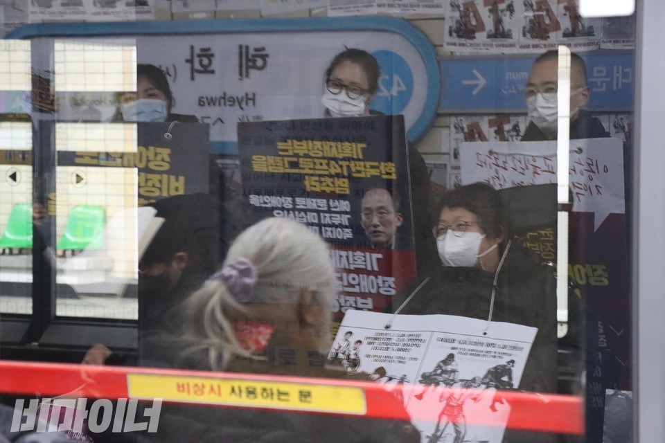 지하철 안전문에 비친 활동가들의 모습. 사진 하민지