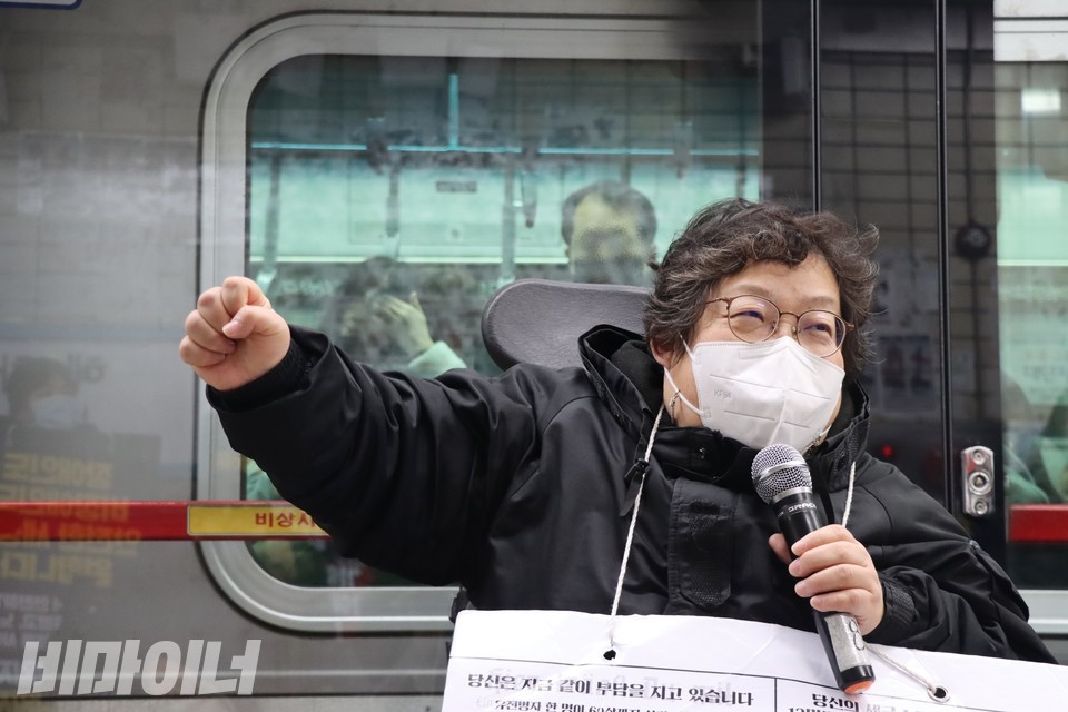이형숙 서울시장애인자립생활센터협의회 회장이 “투쟁”을 외치고 있다. 이 회장 뒤로 열차가 서 있다. 사진 하민지