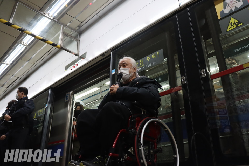 마이크를 들고 발언하는 박경석 전국장애인차별철폐연대 상임공동대표 오른쪽으로 열차가 멈춰 선 뒤 혜화역 승강장 스크린도어가 열리고 있다. 사진 복건우