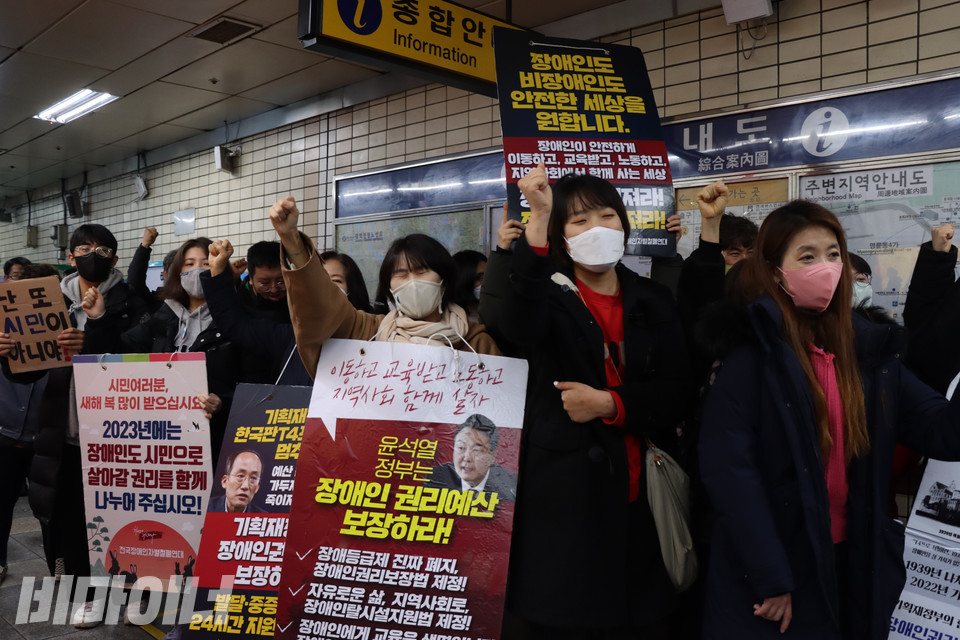 몸피켓을 든 선전전 참여자들이 혜화역 승강장 앞에서 주먹을 불끈 쥐며 구호를 외치고 있다. 사진 복건우