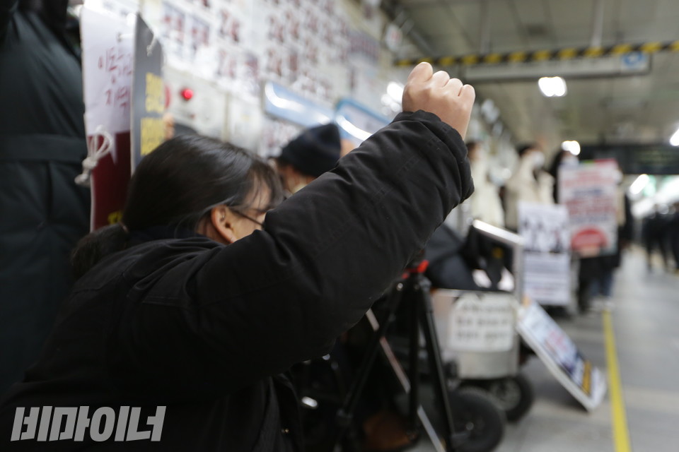 투쟁을 외치며 주먹 쥔 손을 높이 들고 있는 활동가. 사진 강혜민