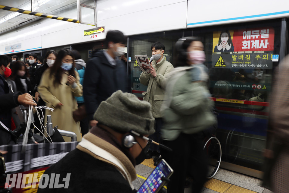 발언하는 석류와 선전전에 참석한 사람들 사이로 사람들이 지나간다. 사진 강혜민 