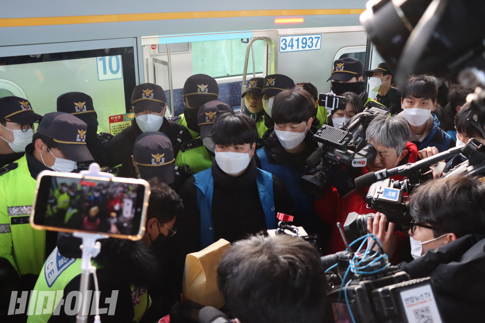 전국장애인차별철폐연대 활동가들이 오이도역 승강장으로 들어오는 열차 탑승을 시도하자, 형광색 패딩을 입은 경찰과 파란 조끼를 입은 한국철도공사 직원이 출입문을 가로막고 탑승을 제지하고 있다. 사진 복건우