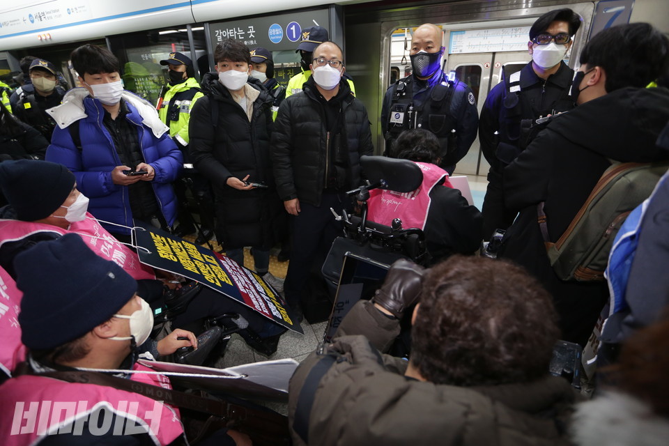 문 앞을 가로막은 보안관과 경찰 사이로 한산한 열차 내부가 보인다. 사진 강혜민 
