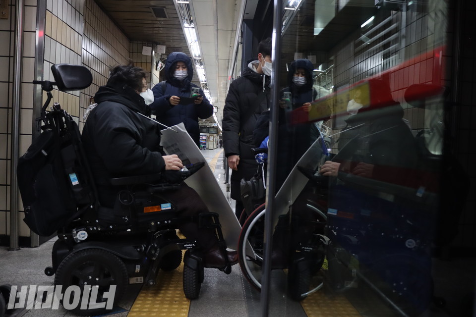 이형숙 서울시장애인자립생활센터협의회 회장(왼쪽)이 25일 오전 서울지하철 4호선 한성대입구역(혜화 방면)으로 들어오는 지하철을 타기 위해 승강장 출입문 앞에 서 있다. 사진 복건우