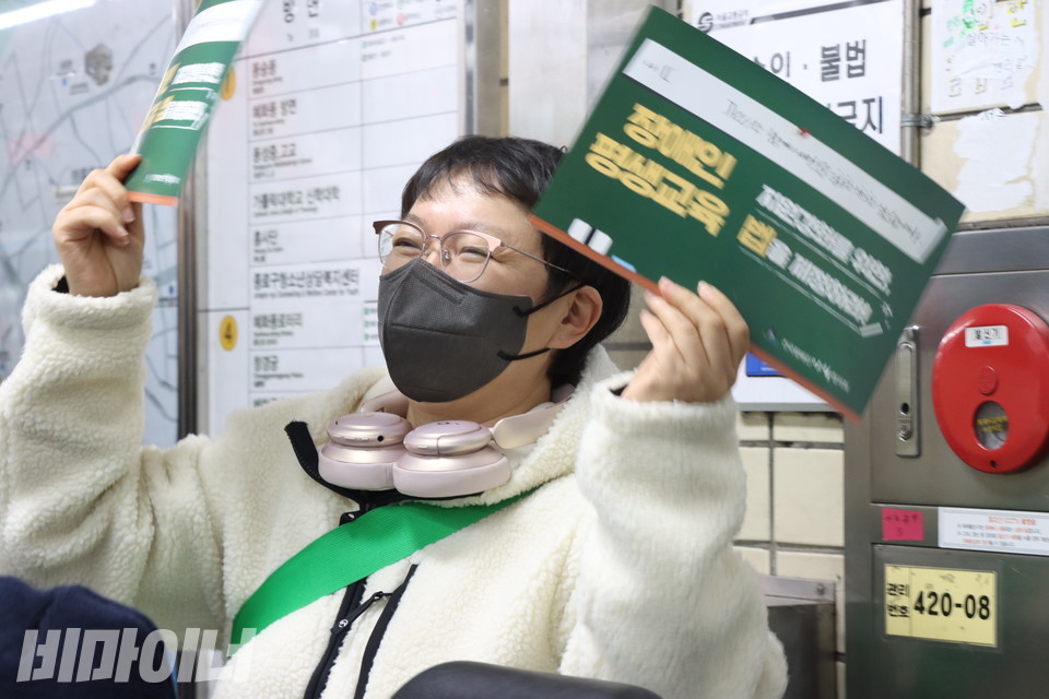 임미경 전장야협 활동가가 장애인평생교육법 제정을 촉구하는 초록 피켓을 들며 환호하고 있다. 사진 강혜민