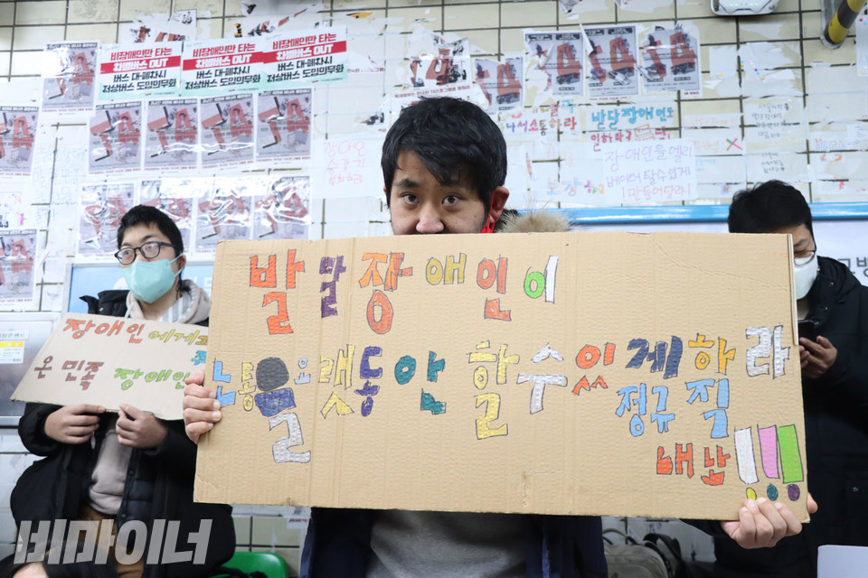 임성재 활동가가 “발달장애인이 노동을 오랫동안 할 수 있게 하라. 정규직 내놔!”라고 적힌 피켓을 들고 있다. 사진 강혜민