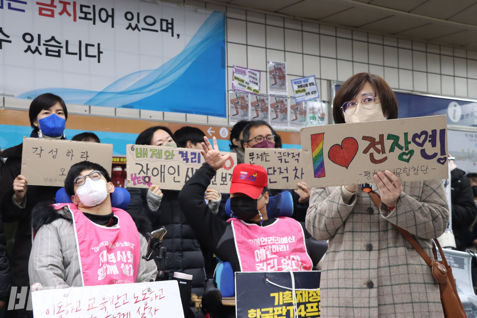 김언경 평화의 나무 합창단원이 무지개색으로 “아이 러브 전장연”이라고 적힌 손팻말을 들고 발언하고 있다. 사진 강혜민