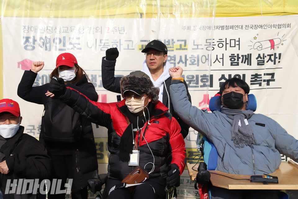 23일 오전 국회 앞 농성장에서 기자회견을 마친 전국장애인야학협의회 활동가들이 주먹을 불끈 쥐어 보이고 있다. 농성장 천막에는 ‘장애인도 이동하고 교육받고 노동하며 지역사회에서 함께 살자’고 적혀 있다. 사진 복건우