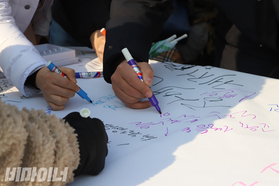 전국장애인야학협의회 소속 장애인들이 23일 오전 국회 앞 기자회견을 마무리한 뒤 흰 천 위에 매직펜으로 장애인평생교육법 제정을 촉구하는 문구를 쓰고 있다. 사진 복건우