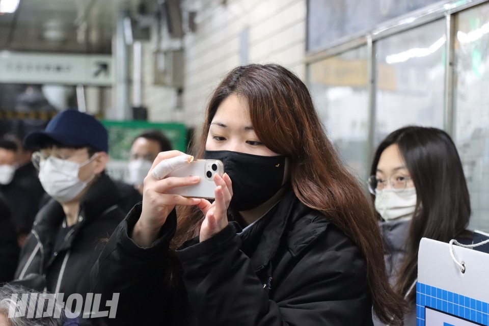 박미주 서울장애인차별철폐연대 활동가가 선전전 현장을 촬영하고 있다. 박 활동가의 오른손 세 번째 손가락에 붕대가 감겨 있다. 사진 하민지