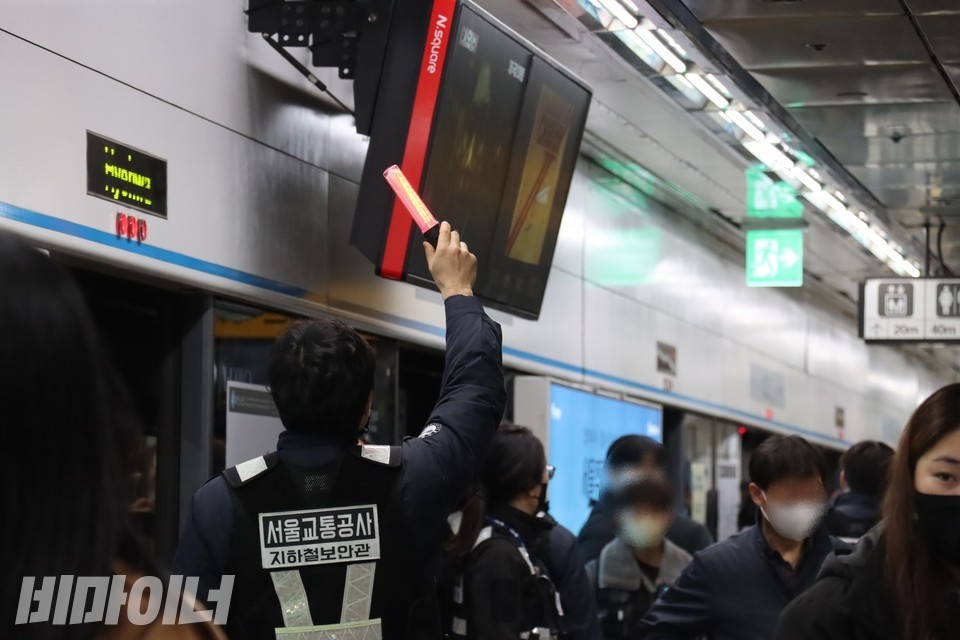 서울교통공사 지하철 보안관이 빨간 경광봉을 들고 열차 출입을 단속하고 있다. 사진 하민지