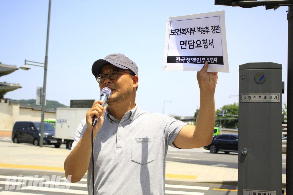 윤진철 당시 전국장애인부모연대 조직국장이 2019년 6월 서울정부종합청사 앞 기자회견에서 박능후 당시 보건복지부 장관 면담요청서를 들어 보이며 발언하고 있다. 사진 비마이너DB