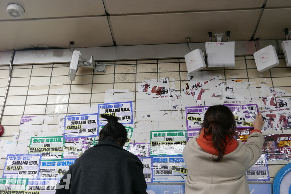 활동가들이 승강장 벽에 스티커를 붙이고 있다. 사진 양유진